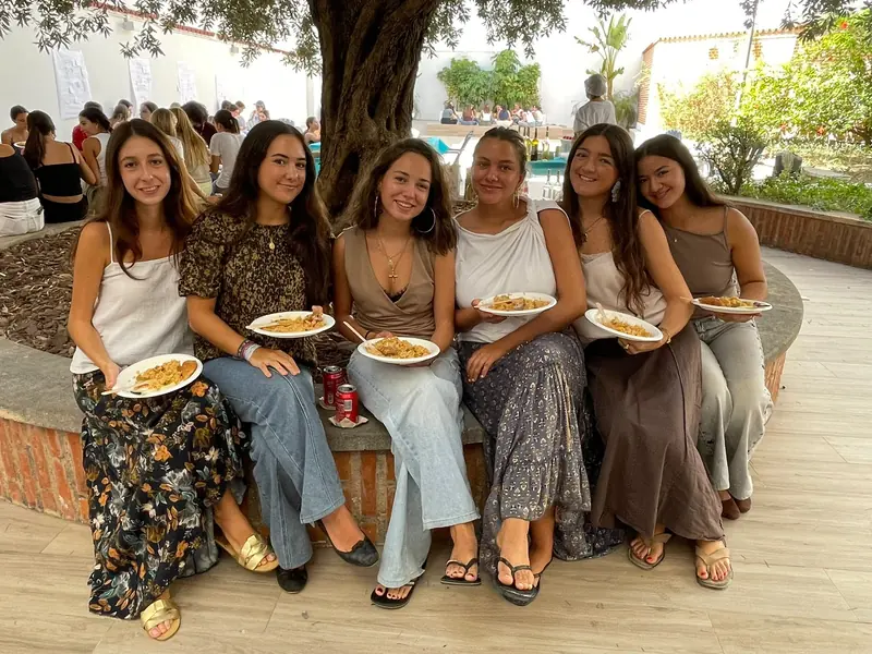 Residentes con sus platos, sentadas en el patio