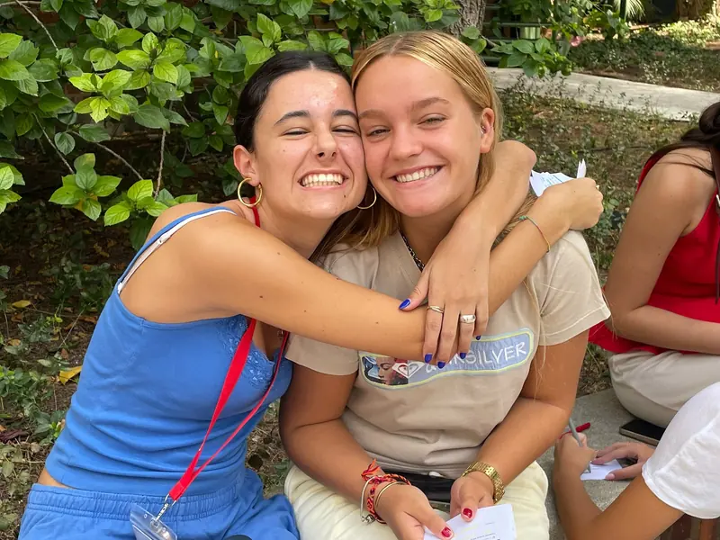 Dos residentes abrazadas y sonriendo en el jardín